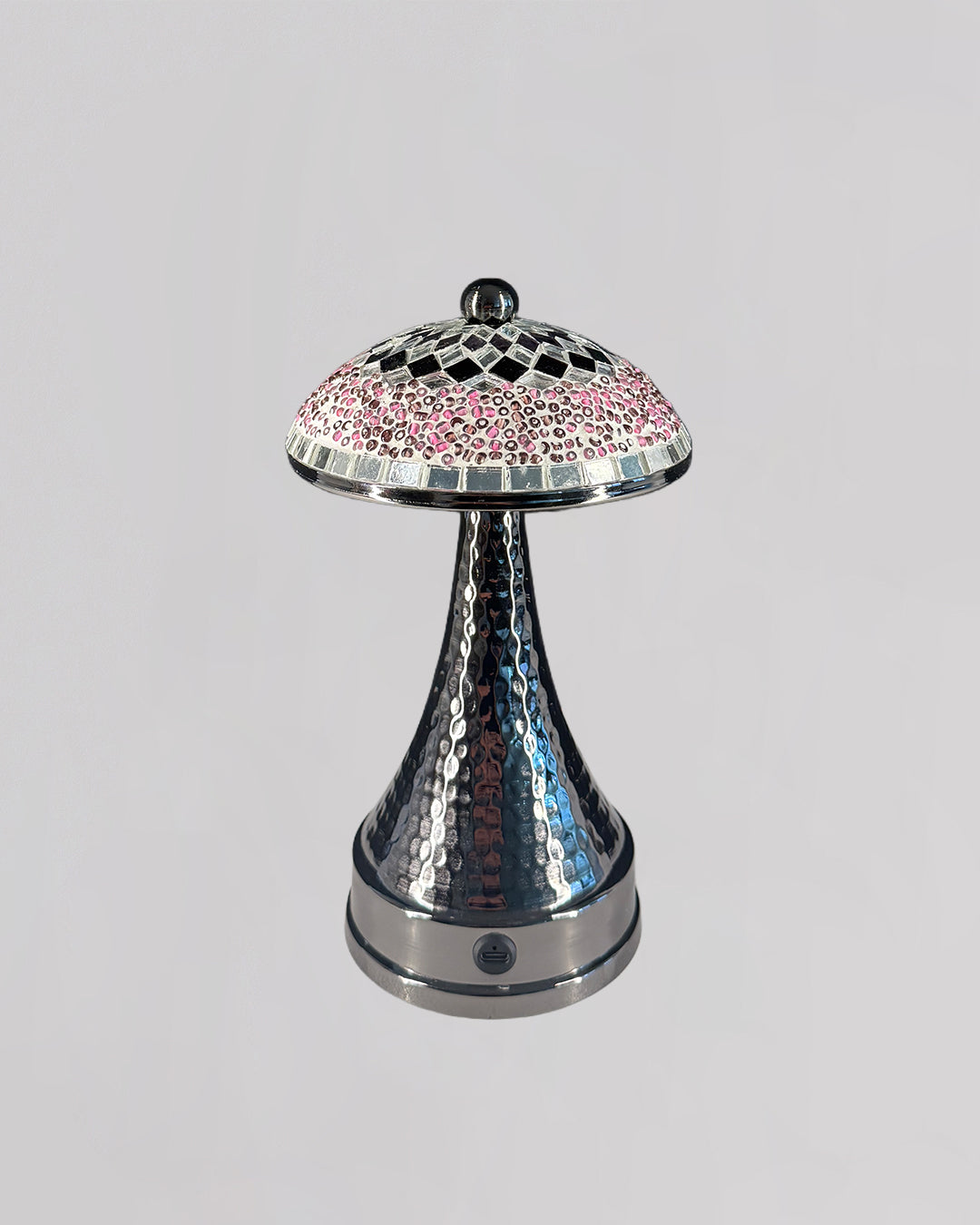 Decorative lamp with a silver base and pink mosaic top on a light gray background