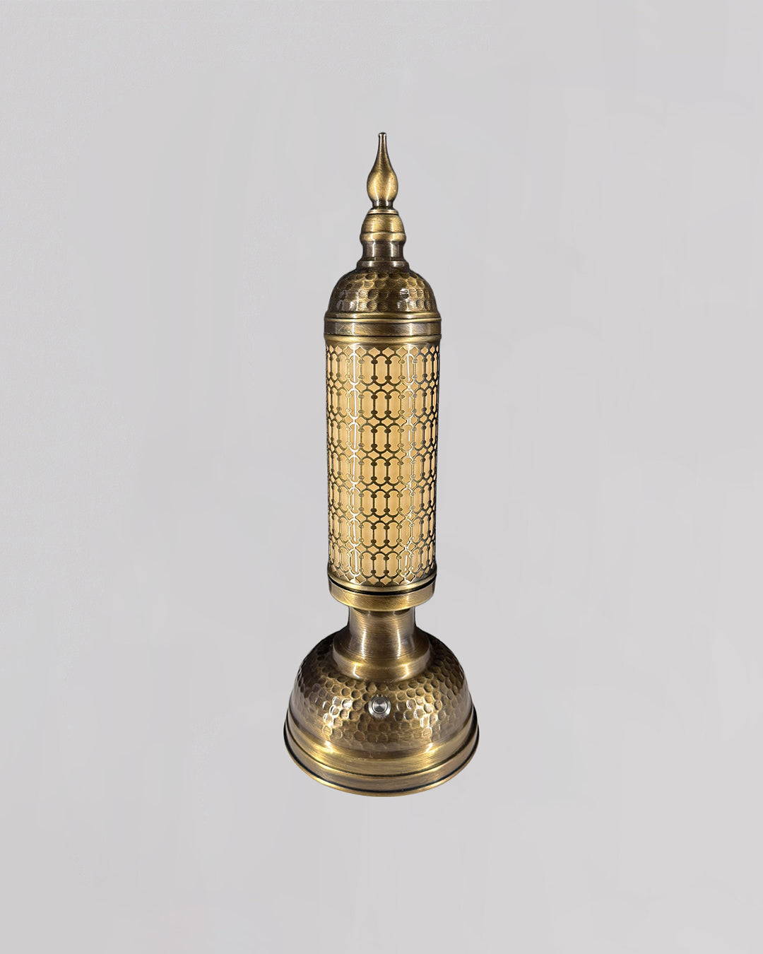 Decorative brass lamp with intricate patterns on a light gray background