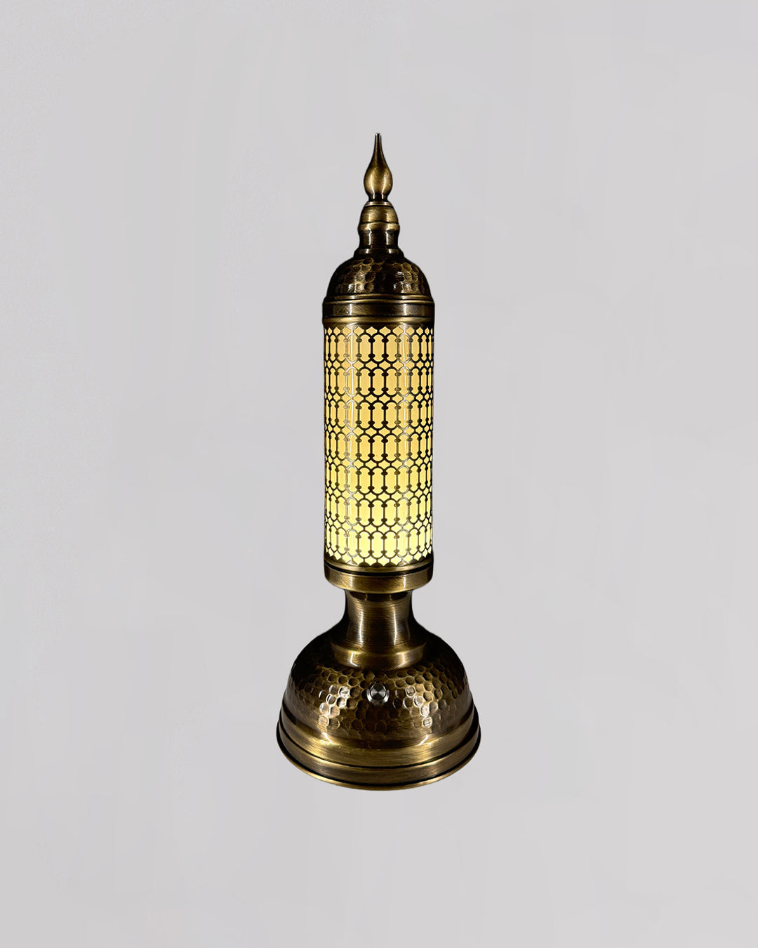 Decorative brass lamp with intricate design on a light gray background