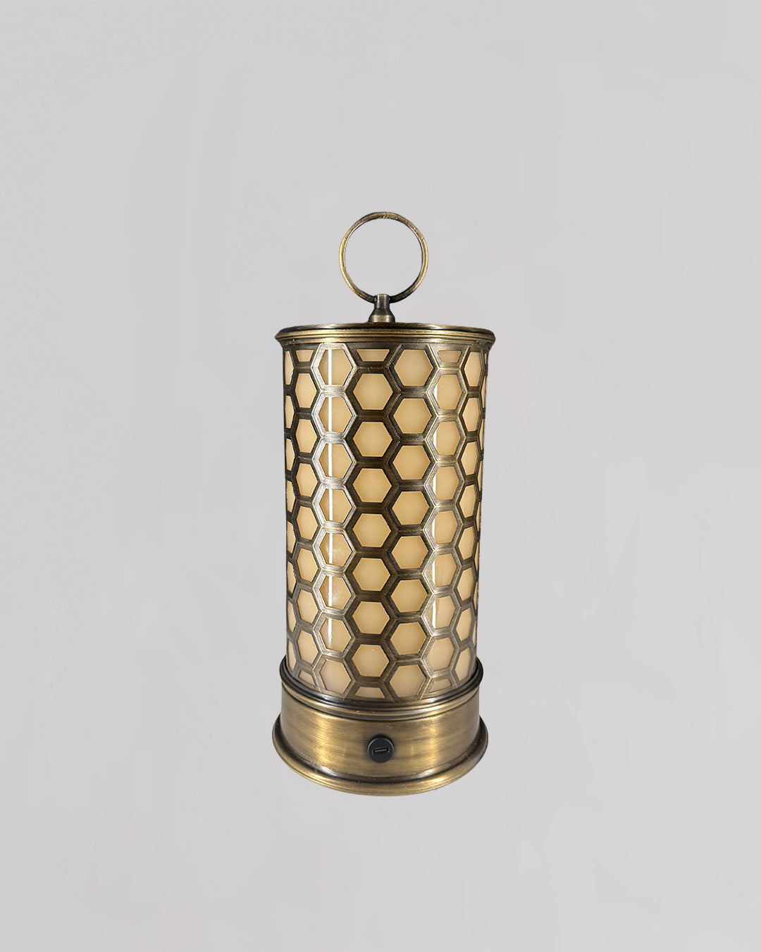 Decorative brass lantern with honeycomb pattern on a light gray background
