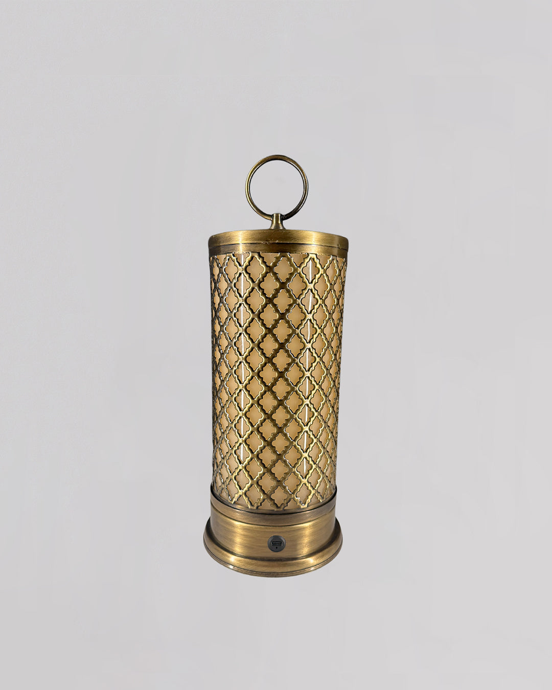 Decorative brass candle holder with intricate patterns on a light gray background