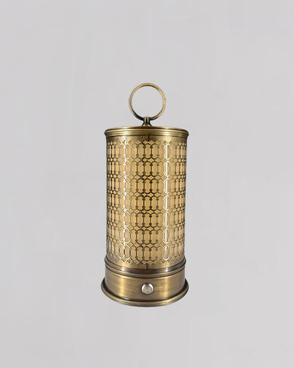 Decorative brass lantern with intricate patterns on a light gray background