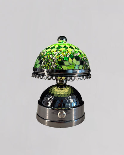 Decorative glass object with green and silver design on a gray background