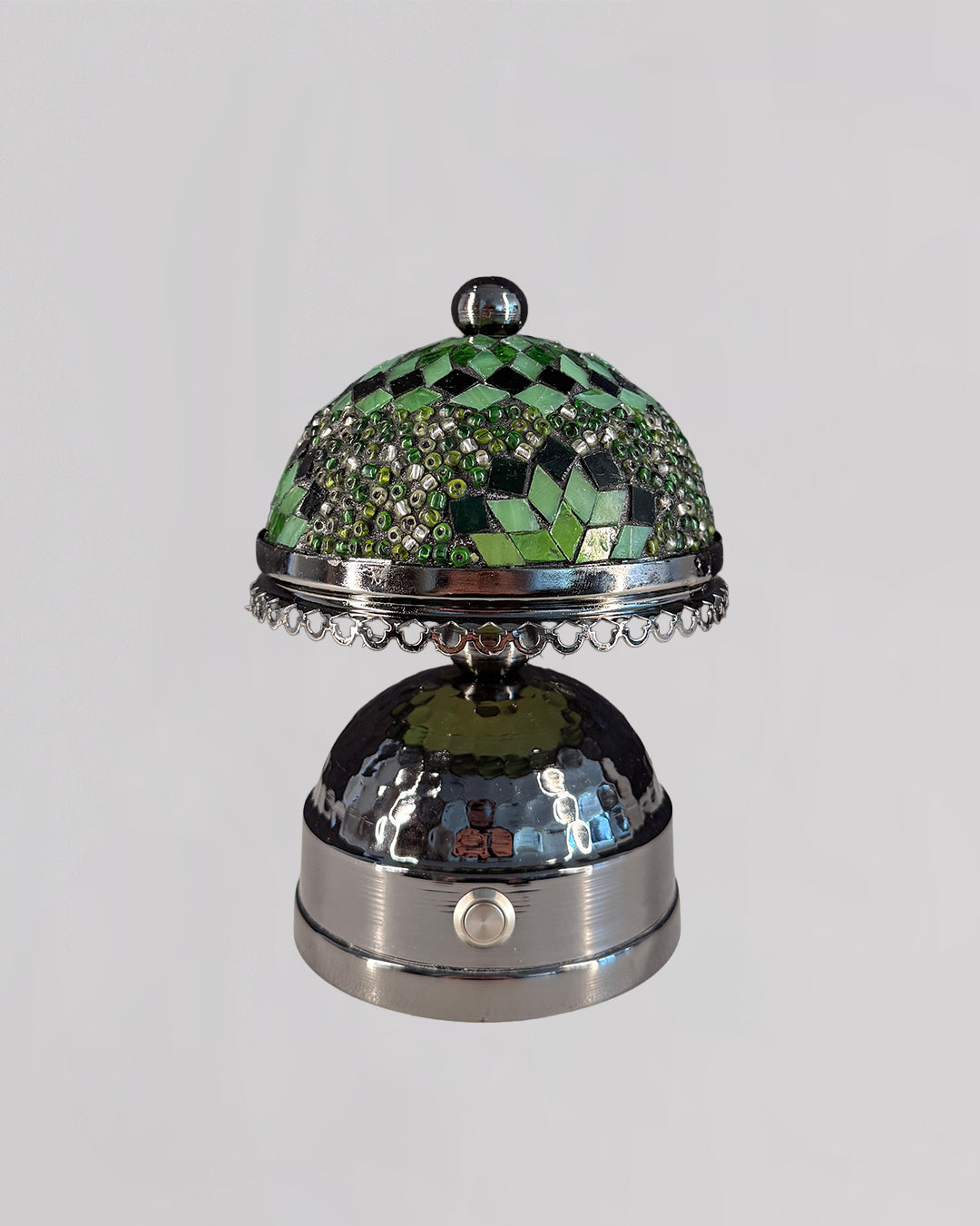 Decorative bell with green mosaic top and silver base on a white background
