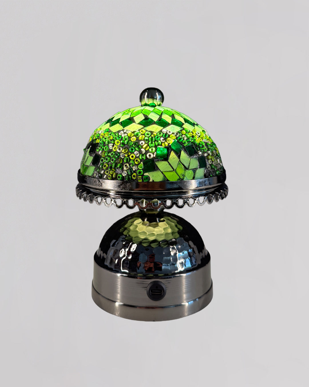 Decorative bell with green checkered top and metallic base on a gray background