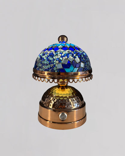Decorative object with blue mosaic top and gold base on a light gray background