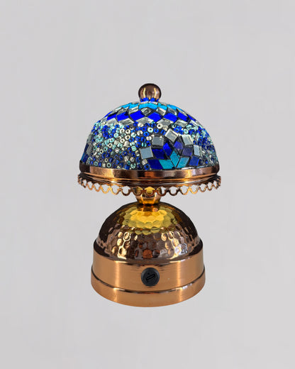 Decorative object with blue mosaic top and gold base on a light gray background
