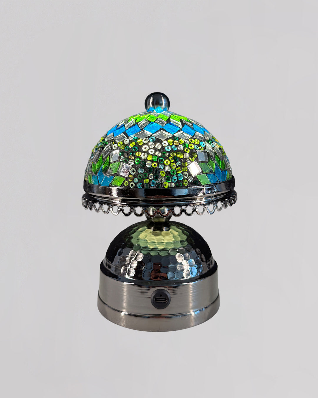 Decorative object with mosaic top and metallic base on a gray background