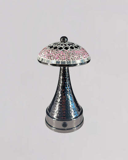 Decorative lamp with a silver base and pink mosaic top on a light gray background