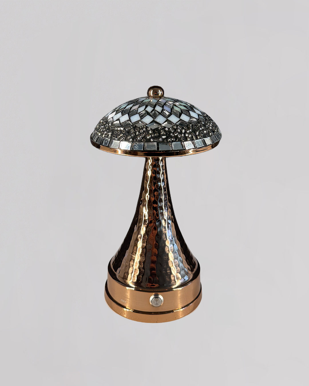 Decorative lamp with mosaic top and textured base on a light gray background