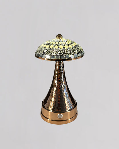Decorative lamp with mosaic top and hammered bronze base on a light gray background