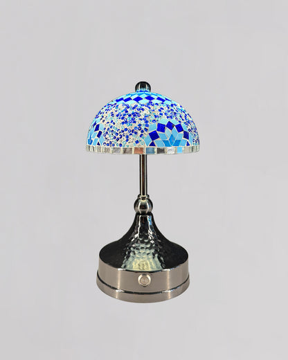 Decorative table lamp with a blue mosaic shade on a gray background